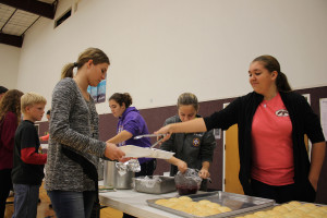 Teen volunteers from First Baptist Church package homemade Thanksgiving food for the elderly.